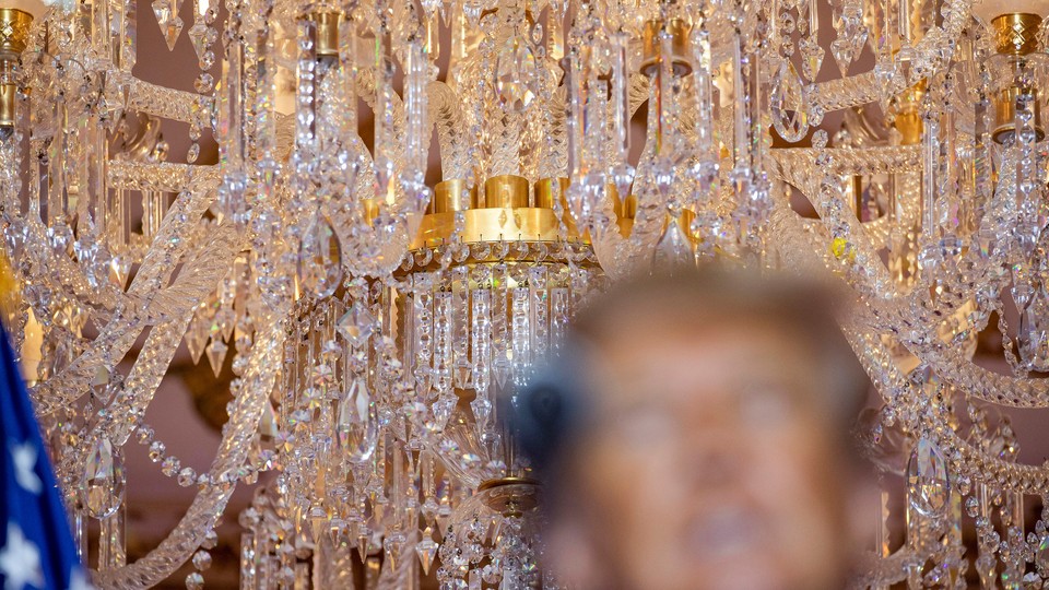 Photo of chandelier behind blurred face of Donald Trump