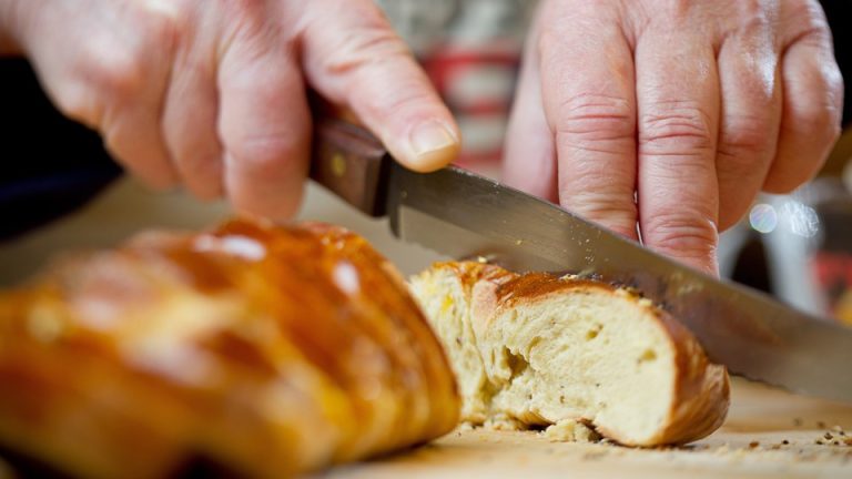 Joan Nathan cuts pain petri, a flavored challah.