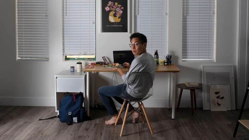 A man eating at a small desk