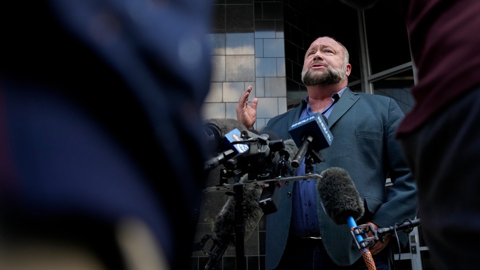 An image of Alex Jones standing at a press conference outside a Houston courthouse.