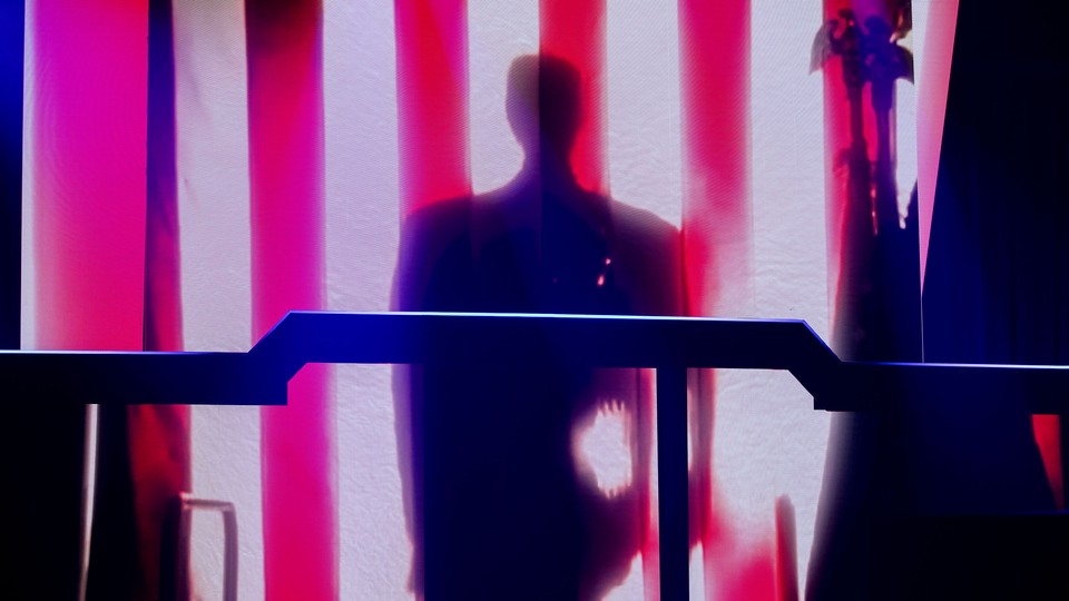 Donald Trump's shadow is illuminated on the stripes of the American flag during a keynote address in Detroit