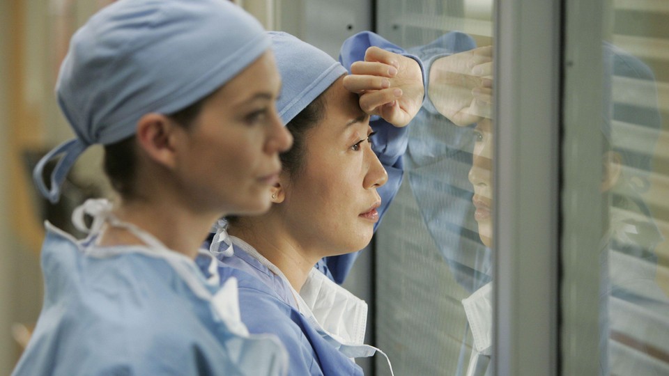 Meredith Grey and Cristina Yang look through a hospital window