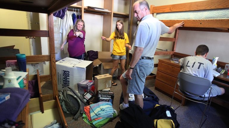 Parents help their daughter, a freshman, move into her dorm at the University of Iowa.