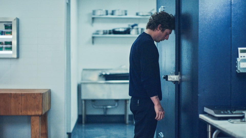 Jeremy Allen White as Carmy rests his head against the door of a walk-in freezer in a scene from Season 3 of "The Bear."