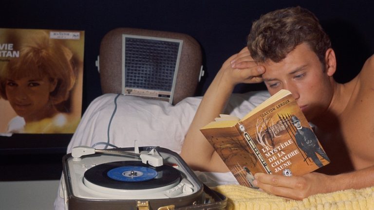 A young man reads a book at night