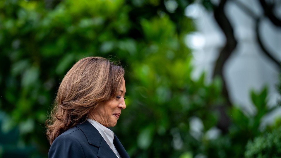 Kamala Harris smiles while looking down and walking