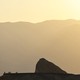 Death Valley an outcropping in front of a mountain in hazy yellow heat