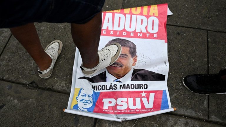 A foot stepping over a sign with Maduro's face