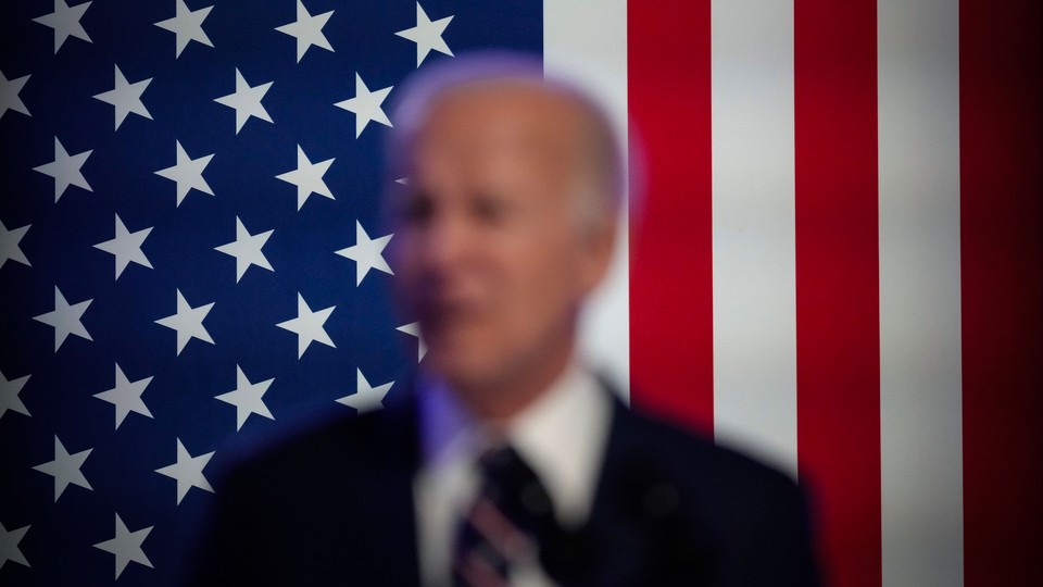 Blurry picture of Biden, the American flag in the background