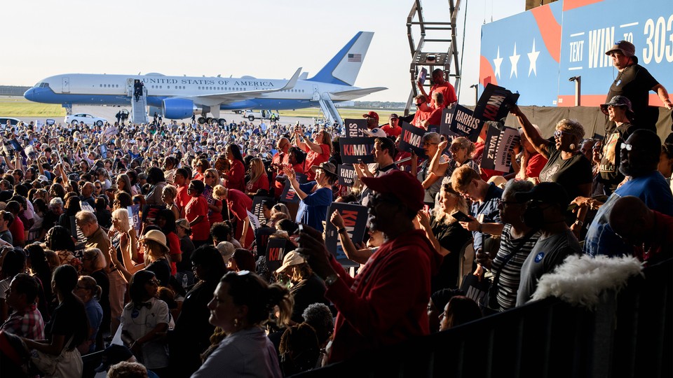 A crowd of people holding signs at a Kamala Harris rally