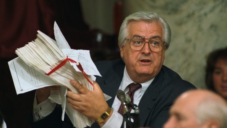 Rep. Henry Hyde holds a stack of papers tied in a red ribbon