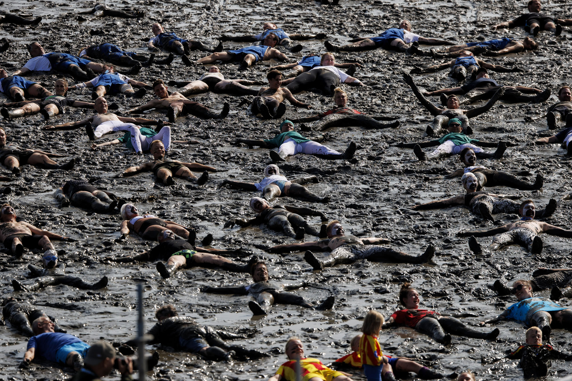 A group of people make mud angels