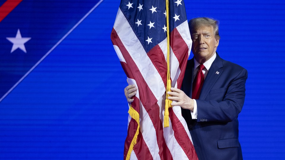 Donald Trump hugs an American flag