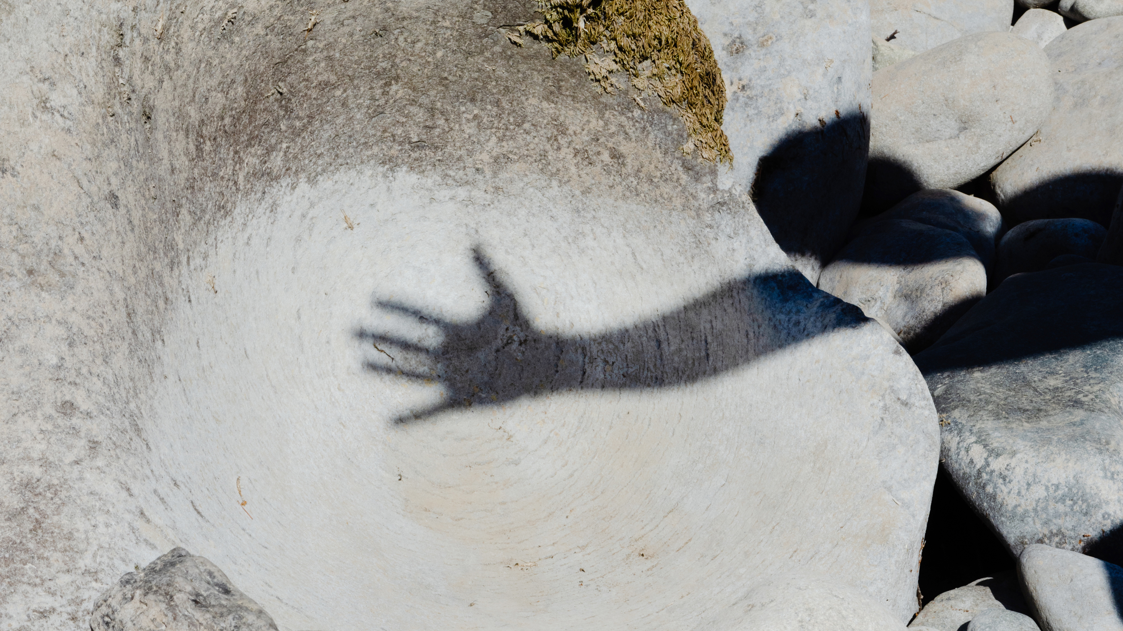 The shadow of a hand on a big rock