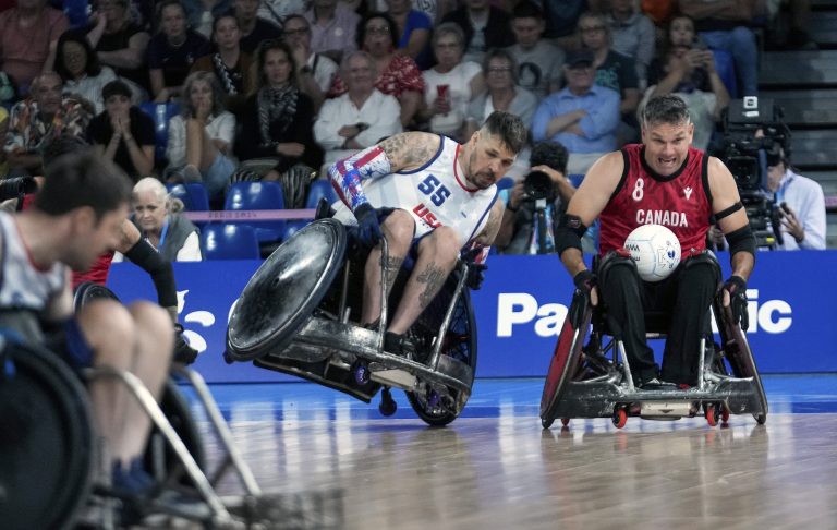 Two wheelchair rugby competitors vie for a ball during a match at the Paralympic Games