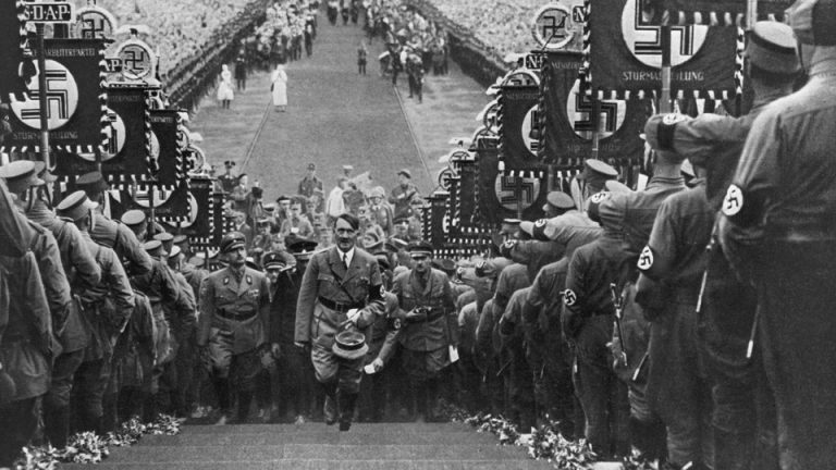 A photo of Hitler walking in a Nazi military parade