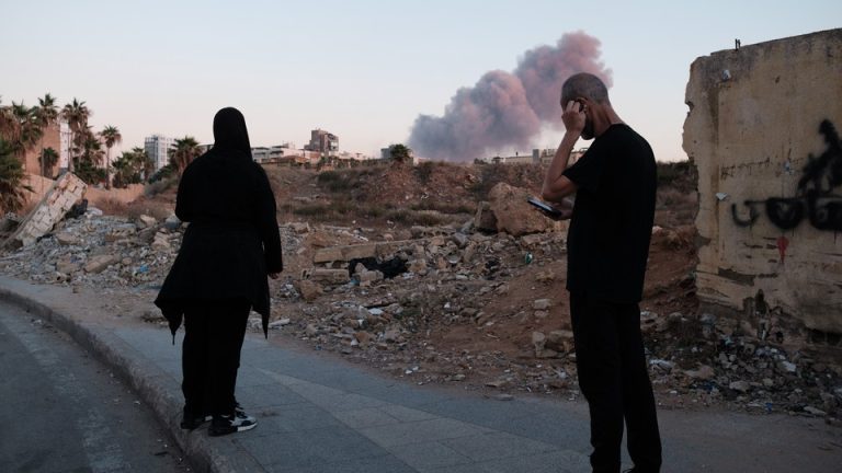 People in Beirut view the smoke rising above the site of an Israeli strike on Hassan Nasrallah