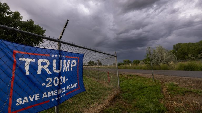 A storm brews in the sky above a Trump 2024 flag