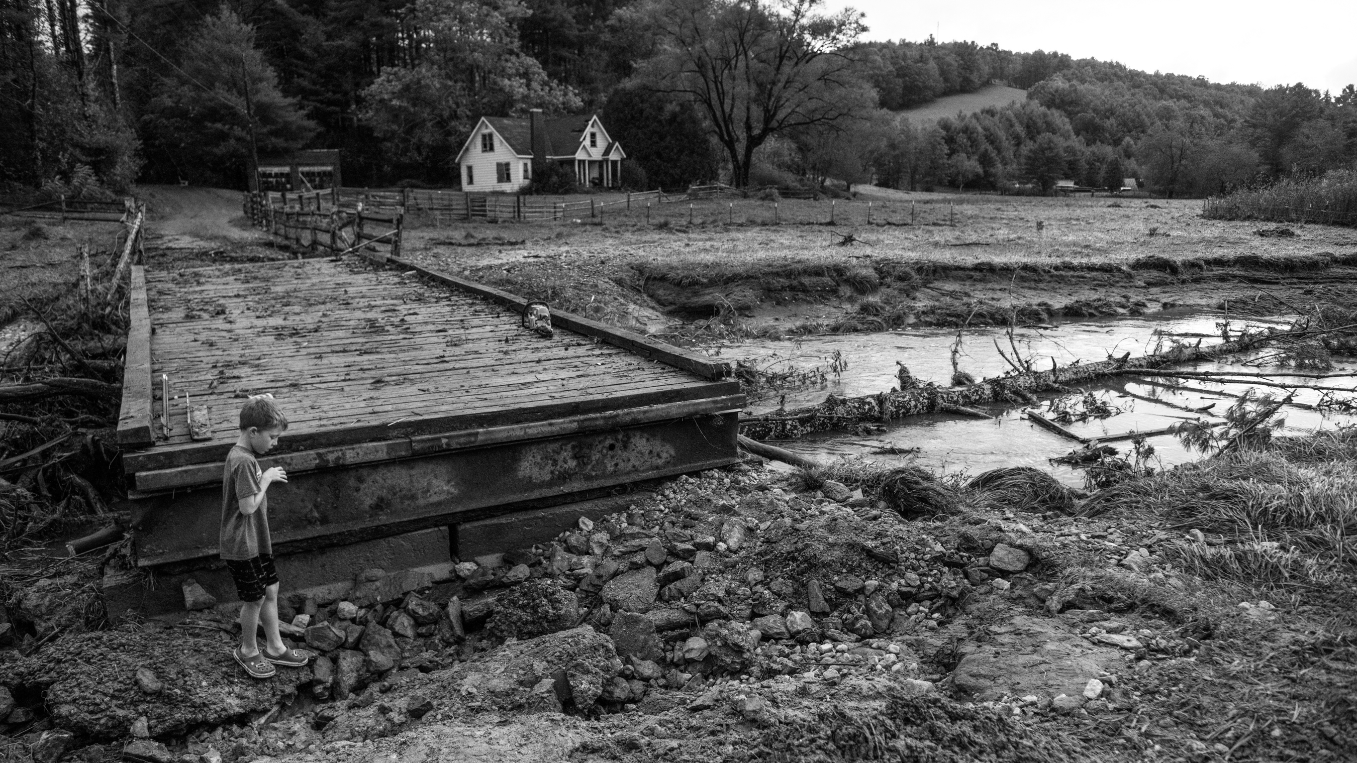 A boy plays near the remainder of a washed-out road near his family's home in Watauga County on September 27, 2024.