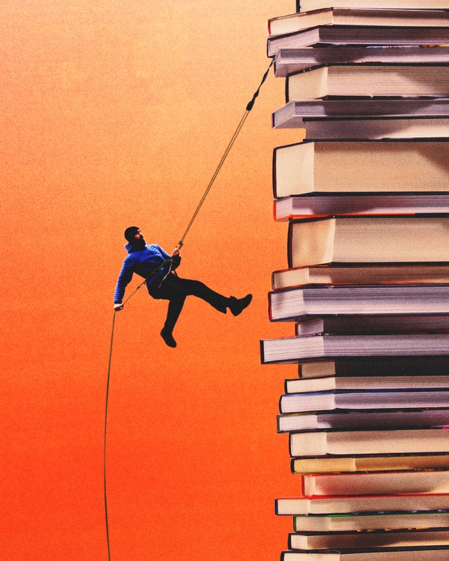 A man rappelling down a stack of books