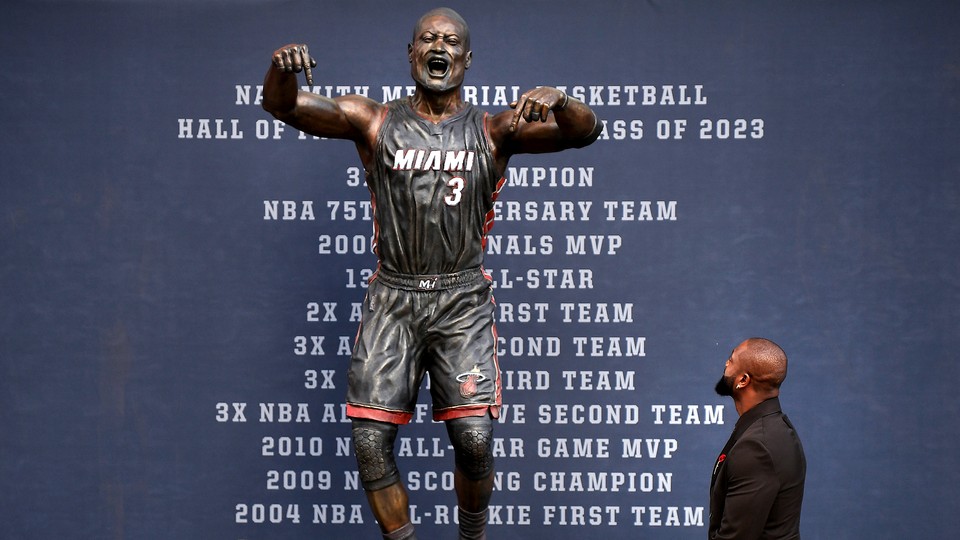 A photo of Dwayne Wade looking up at the newly-unveiled statue