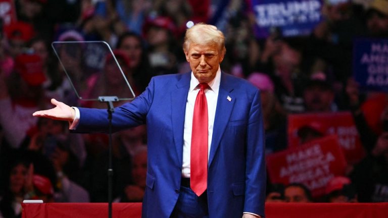 Trump stands with his left arm outreached at Madison Square Garden