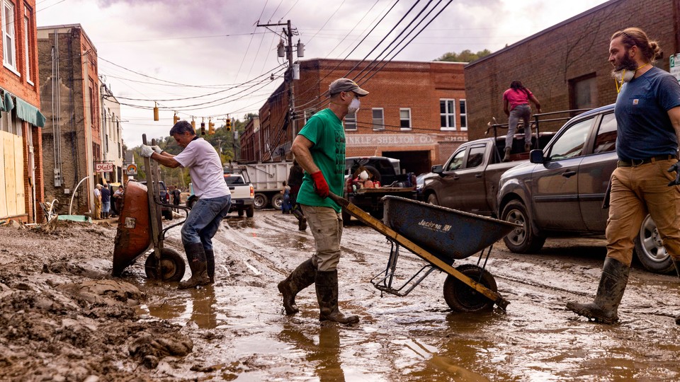 Residents and volunteers clean up on Tuesday, Oct. 1, 2024, after the French Broad River flooded downtown Marshall, North Carolina. The remnants of Hurricane Helene caused widespread flooding, downed trees, and power outages in western North Carolina.