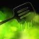 An illustration of a black plastic spatula melting in a neon-green cloud.