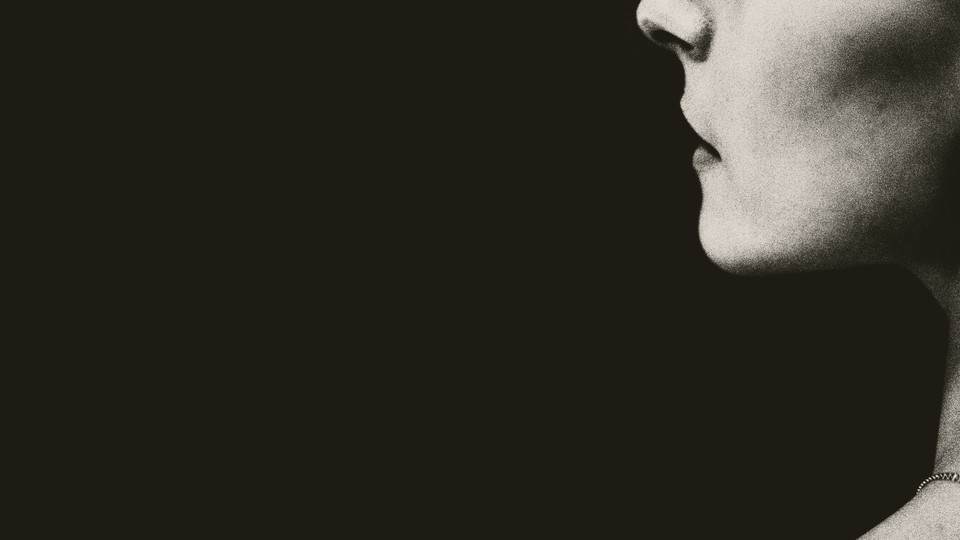 Half of a woman's face in profile against a black background