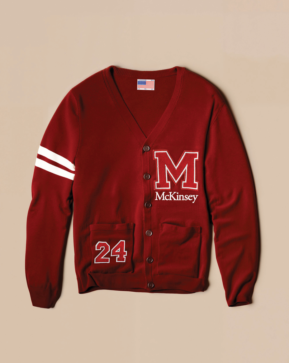 photo-illustration of crimson college button-down cardigan sweater with two white strips on one sleeve, a large "M" on the chest with "McKinsey" embroidered below it, and an embroidered "24" on the lower left pocket, and an American flag tag inside the neck