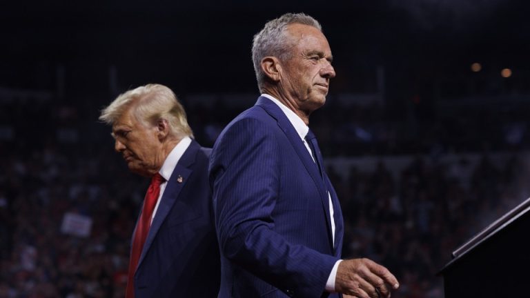 Robert F. Kennedy Jr. walks past Republican presidential nominee Donald Trump during a campaign event