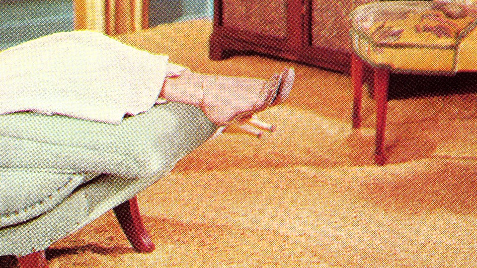 A woman's legs and feet hang over the end of a couch in a therapy office.