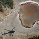 An air interdiction helicopter from U.S. Customs and Border Protection flies past a drought-stricken pond by the U.S.-Mexico border