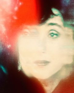 A colorful photograph of a projected image of Cher