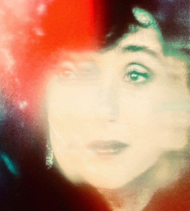 A colorful photograph of a projected image of Cher