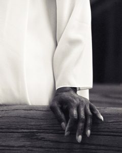 close-up of a hand resting on a pew