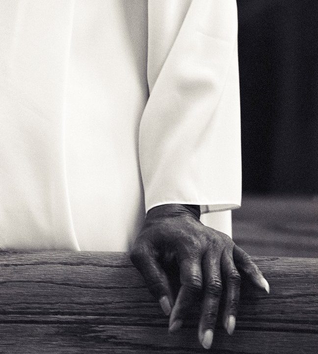 close-up of a hand resting on a pew