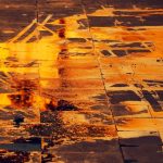 a puddle on the street, reflecting orange light