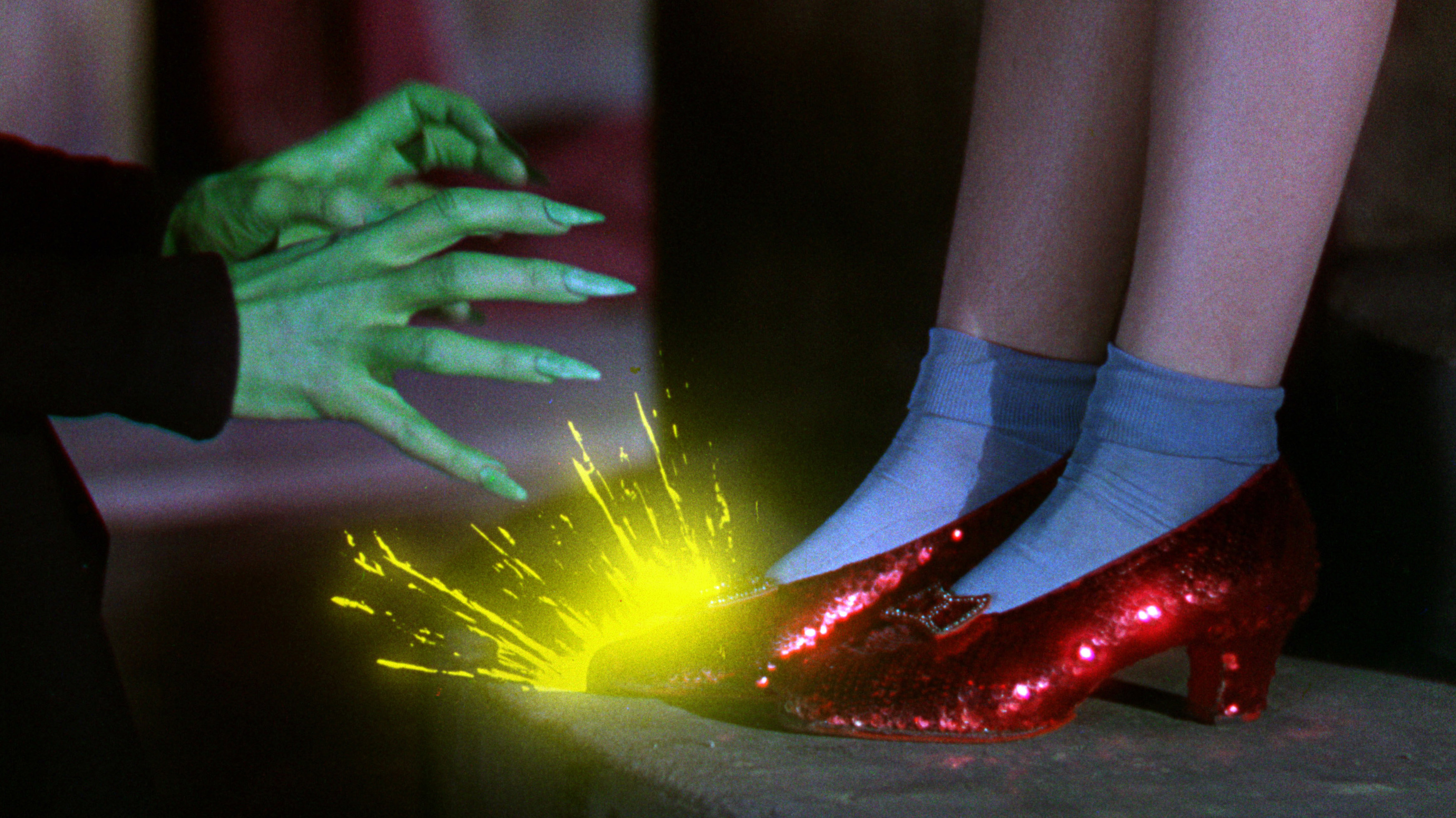 The green Wicked Witch of the West grabs Dorothy's red shoes, which spark