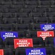 Empty chairs in a venue with “Make America Great Again” signs on them