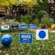 Blue political signs in a front yard with a house behind it