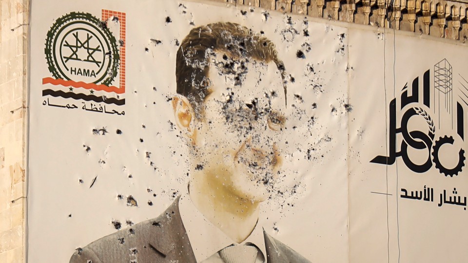 Photograph of an image of Syrian President Bashar Assad, riddled with bullets