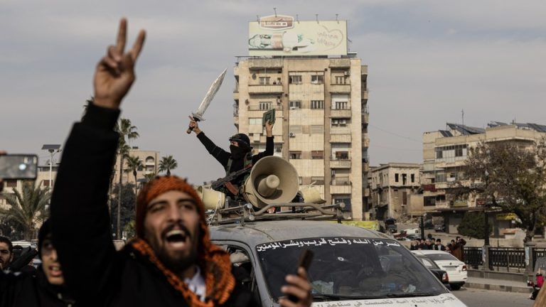 National Syrian Army soldiers celebrate in Hama, Syria, throwing up a peace sign