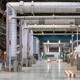 inside a nuclear plant in california, a series of three large silver pipes bend at right angles