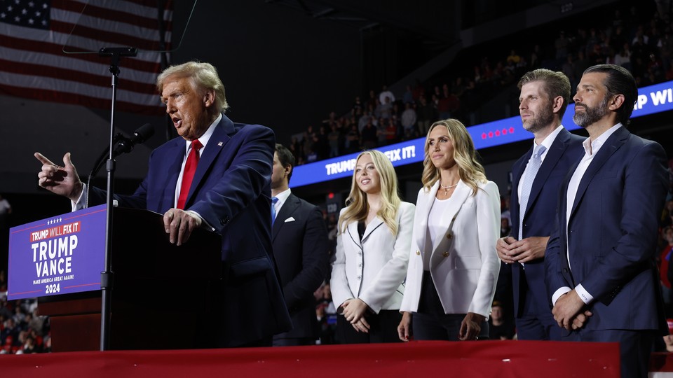 Donald Trump speaks at a campaign event, standing in front of Tiffany Trump, Lara Trump, Eric Trump, and Donald Trump Jr.