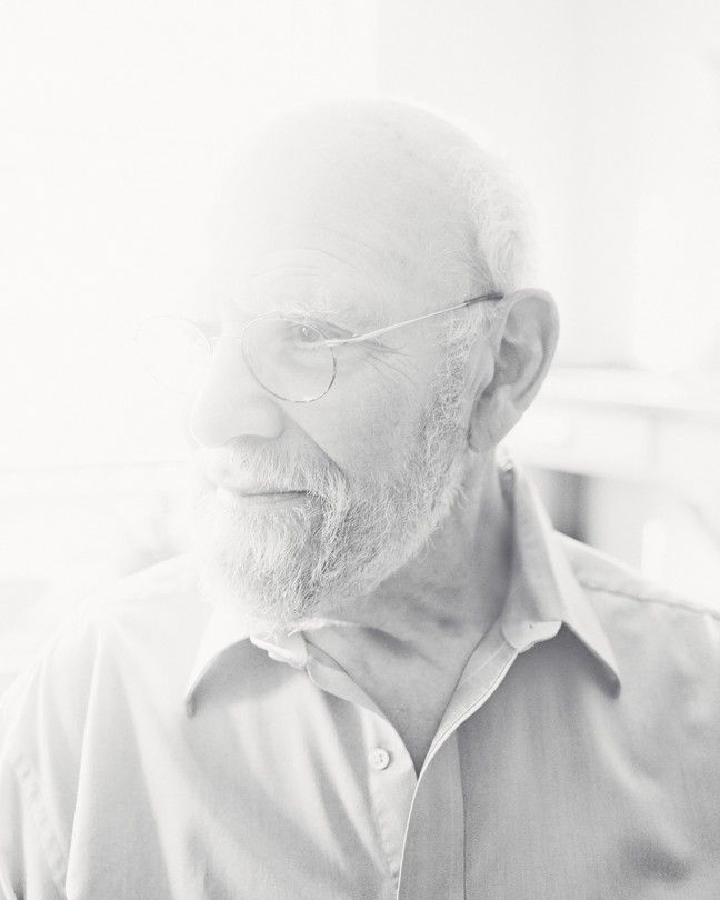 A black-and-white photo of a man with glasses and a beard