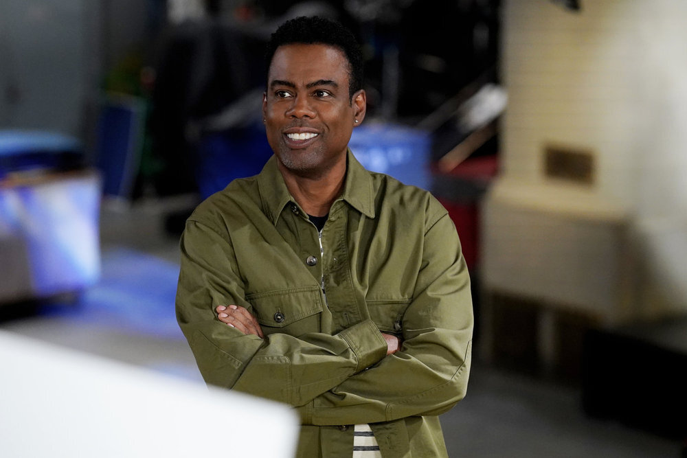 Chris Rock crossing his arms and smiling