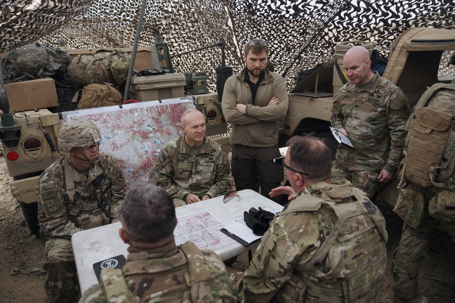 Army men sit around a table