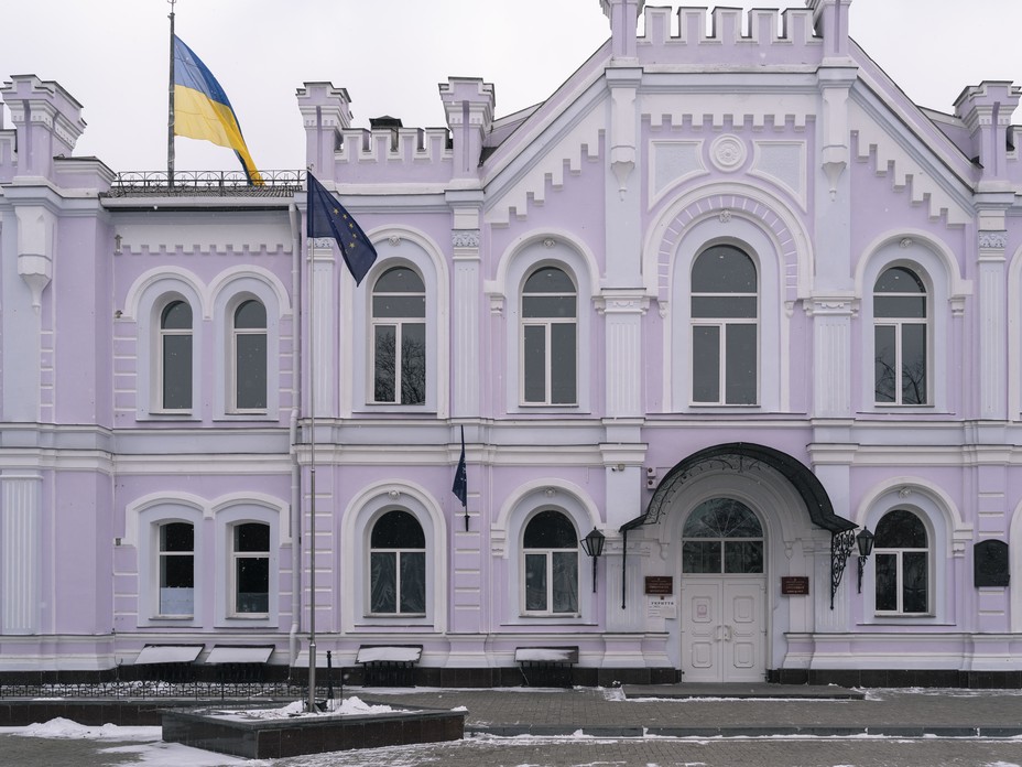 Picture of Sumy National University with a European Union flag in front of it.