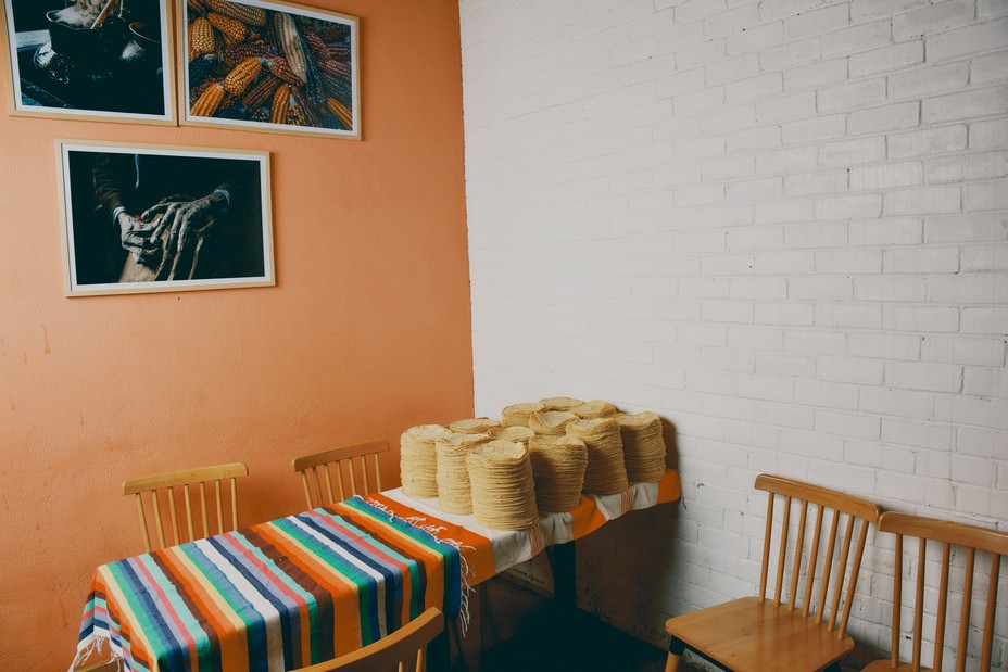 Stacks of tortillas sit on a table in a corner